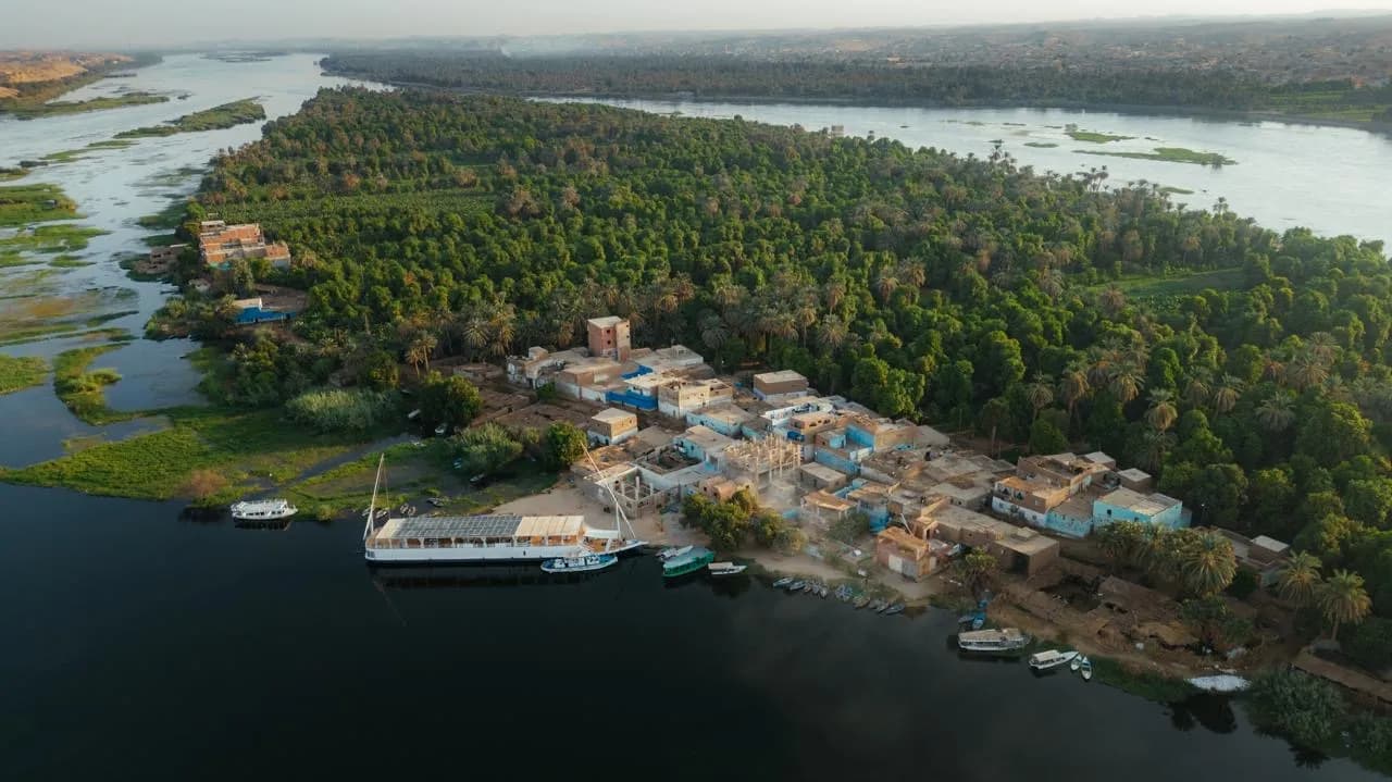 Le Mandala amarré au bord d'un village, vu du ciel